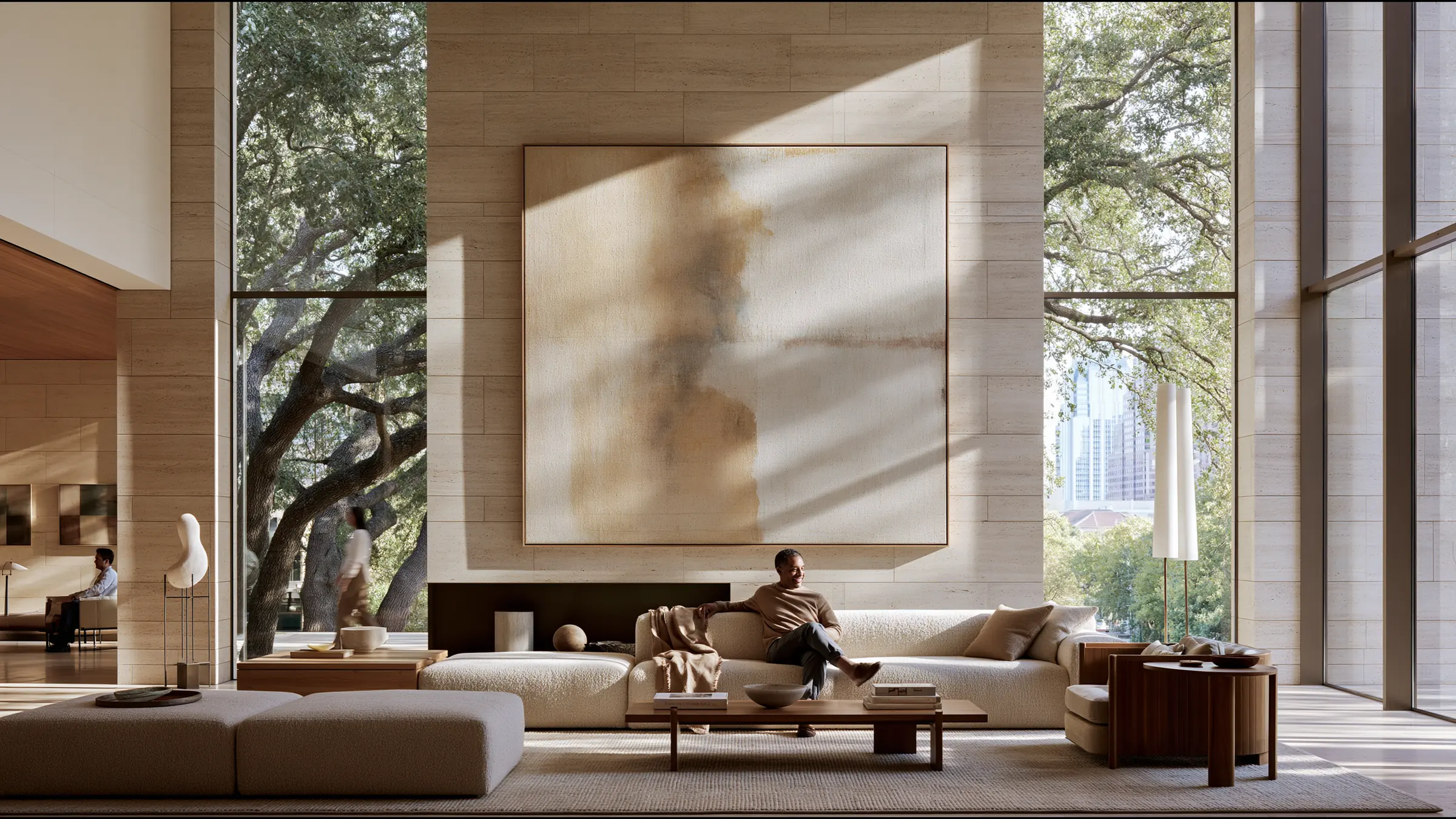 A clinic director in fine knit seated alone on a deep bouclé sofa in a light-filled double-height clinic lounge in Austin, a quiet smile of a goal met, limestone walls, a large abstract painting