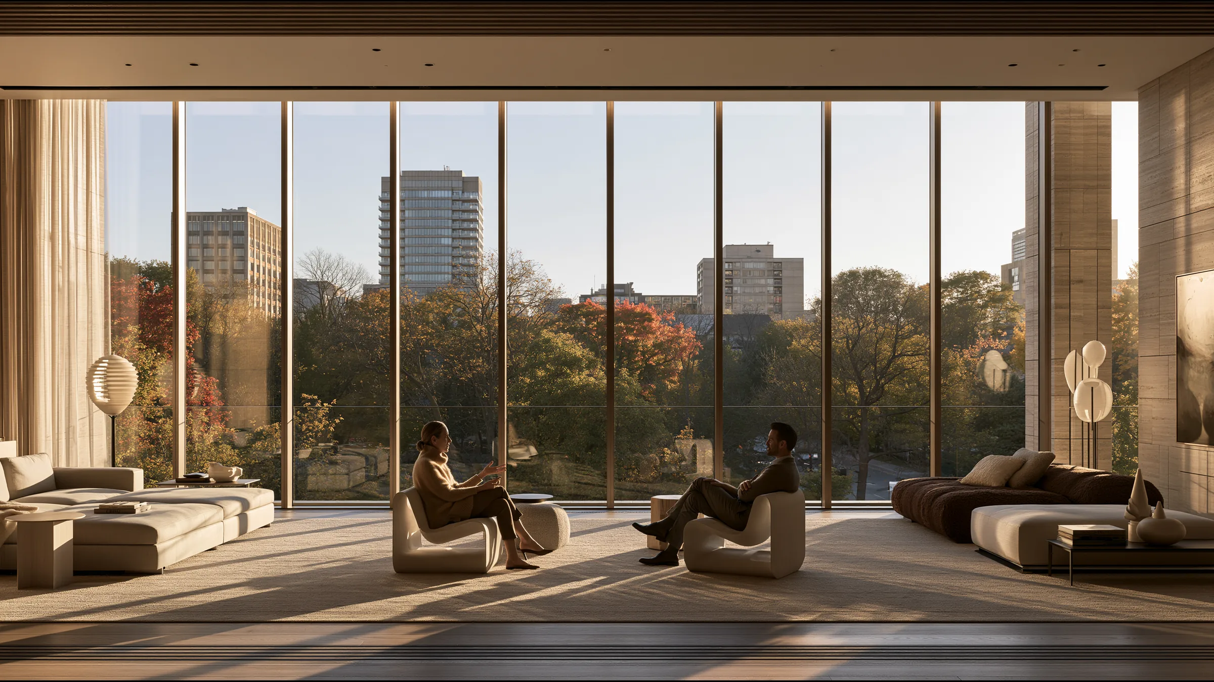 A woman in her fifties talking easily with her doctor on two sculptural chairs in a vast sunlit Yorkville consulting suite in Toronto, both autumn light