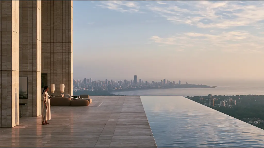 A woman in a white kurta standing on a stone terrace beside an infinity pool, the Mumbai skyline across the bay at dawn